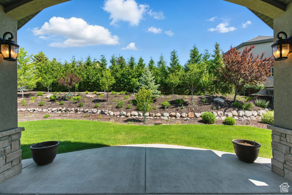 View of grassy yard featuring a patio area