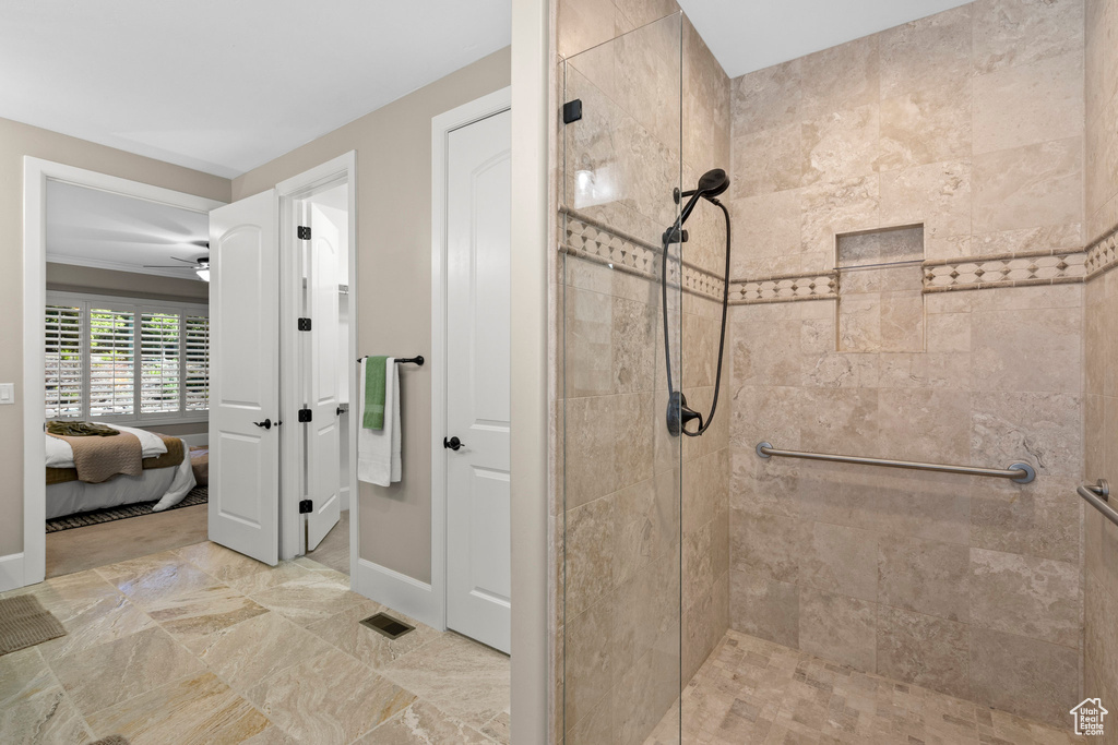 Ensuite bathroom with a stall shower and a ceiling fan