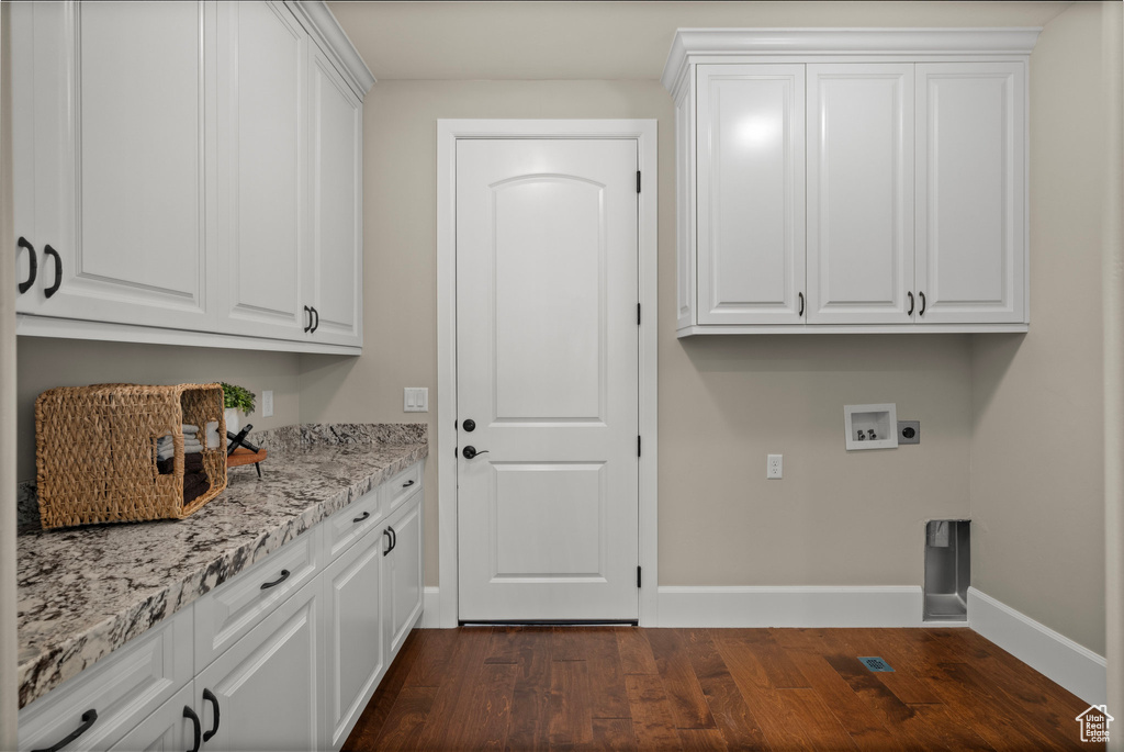 Laundry room featuring cabinet space, dark wood-type flooring, washer hookup, and electric dryer hookup