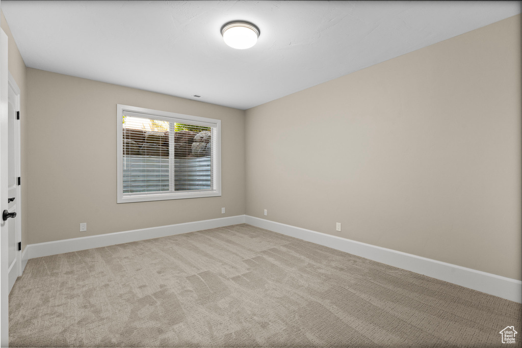 Unfurnished room featuring baseboards and light colored carpet