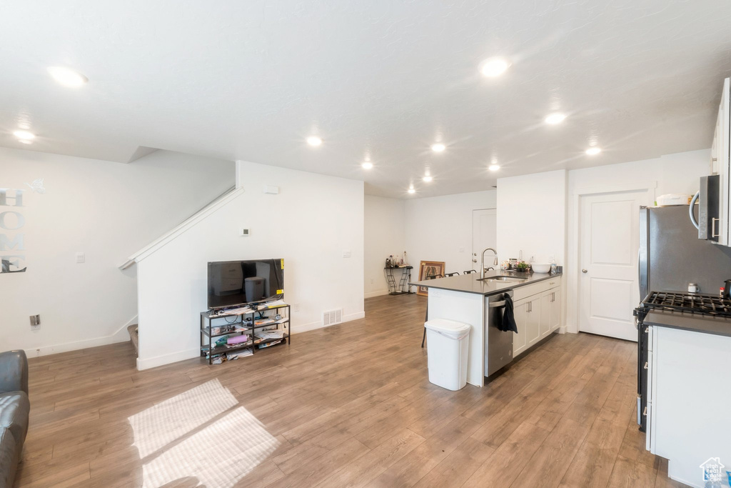 Kitchen with open floor plan, dark countertops, recessed lighting, a peninsula, and appliances with stainless steel finishes