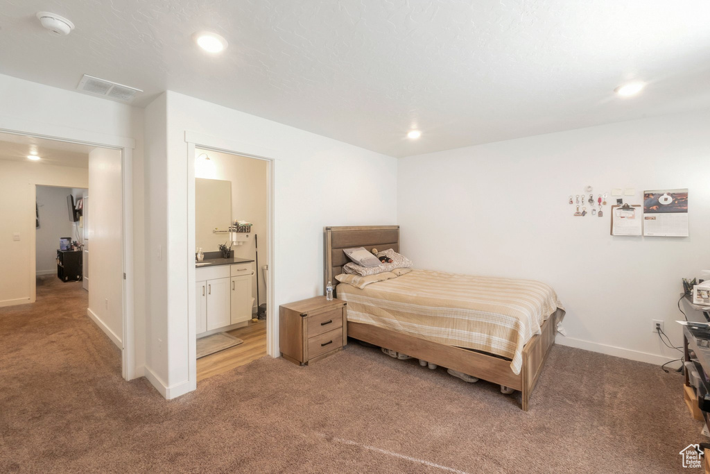 Bedroom featuring light carpet, recessed lighting, and connected bathroom