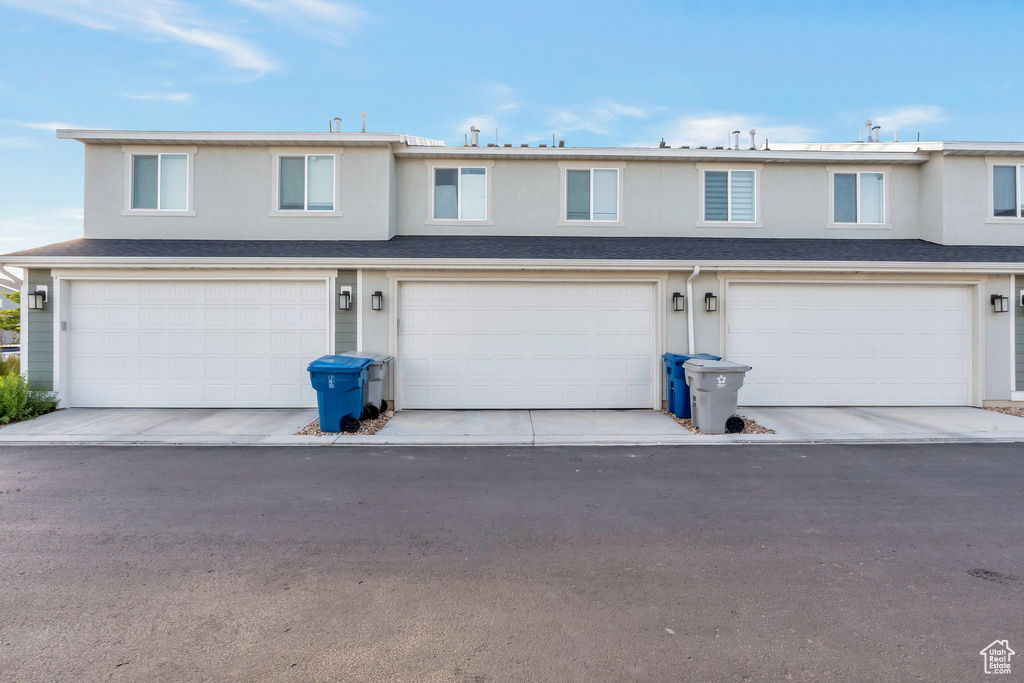 View of front of house featuring a garage and stucco siding