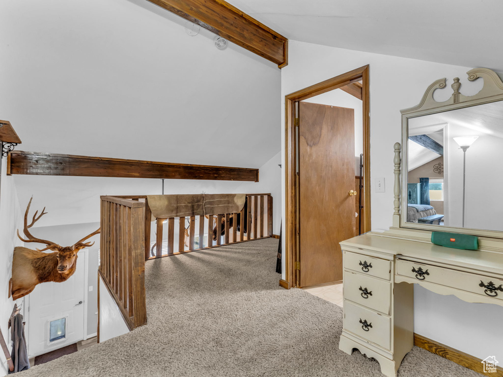 Hall with light colored carpet and an upstairs landing