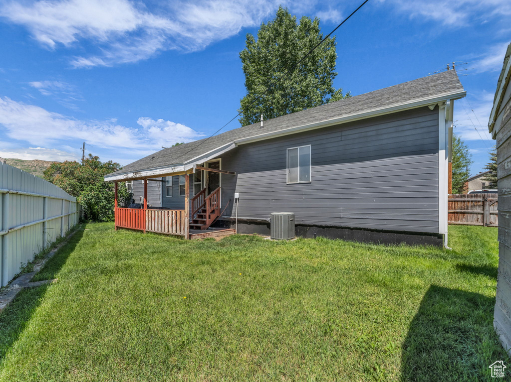 Rear view of property with a fenced backyard and a wooden deck