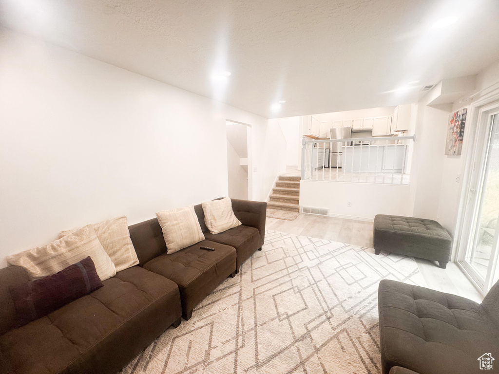 Living room featuring stairs and light wood-style floors