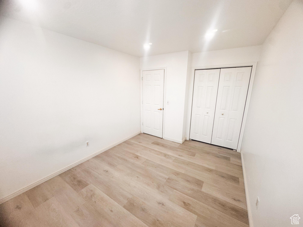 Unfurnished bedroom featuring wood finished floors and a closet