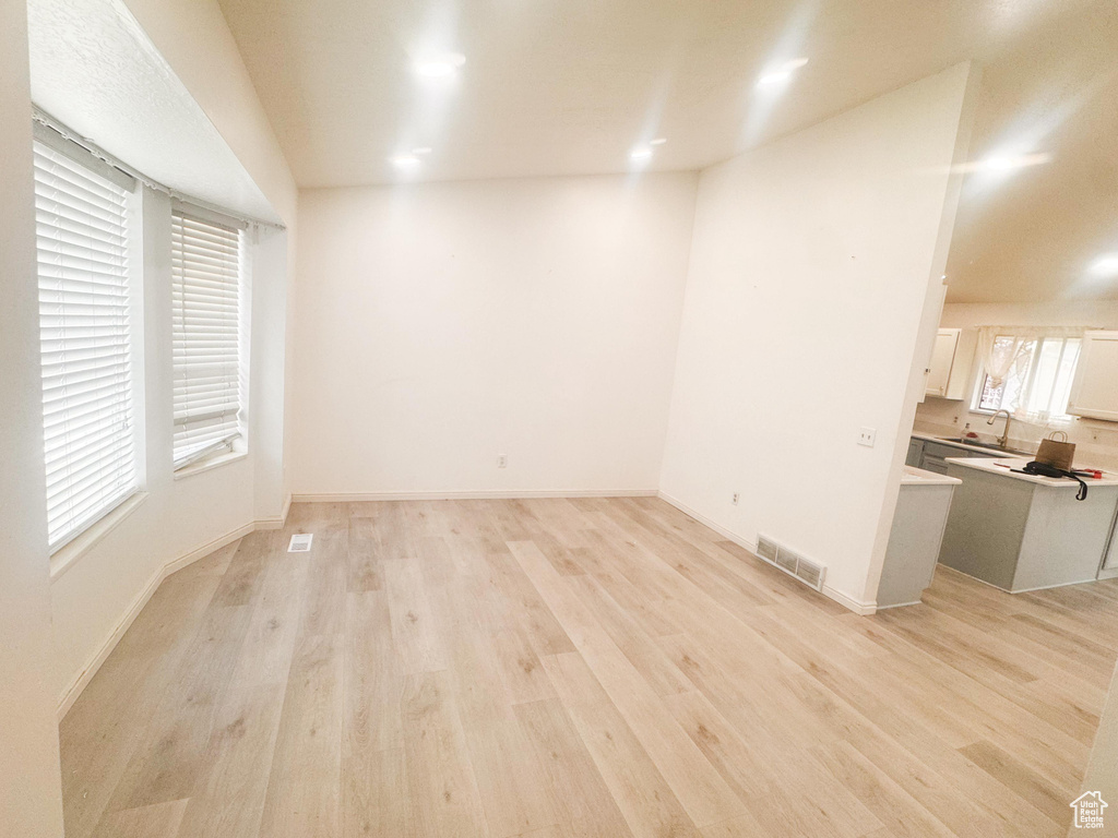 Unfurnished living room with a sink and light wood-type flooring