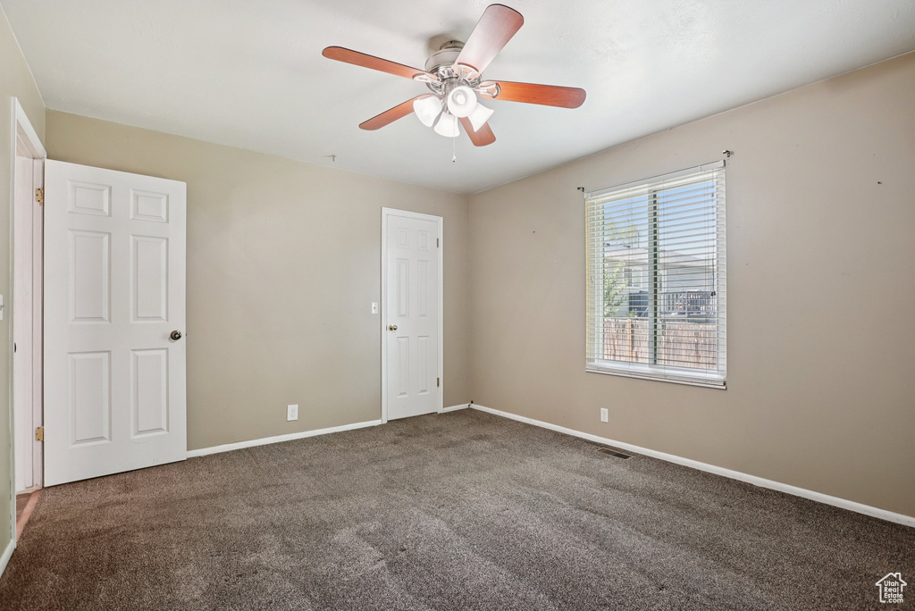 Unfurnished room with ceiling fan and carpet