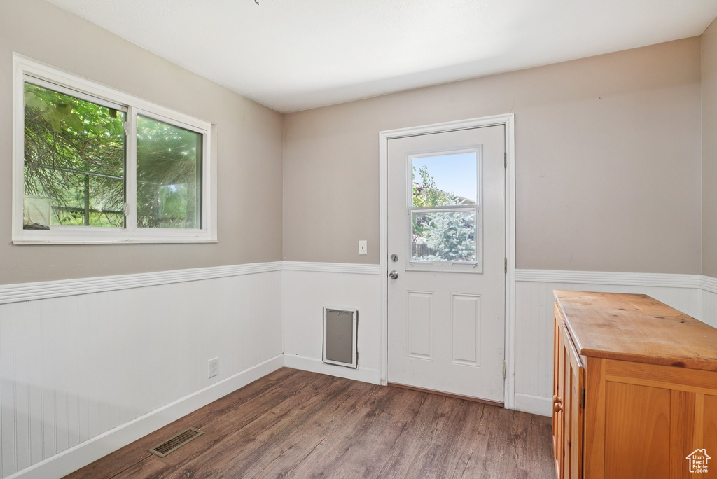 Entryway featuring plenty of natural light, wood finished floors, and wainscoting