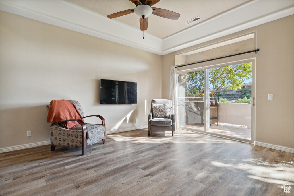 Sitting room with wood finished floors and a ceiling fan