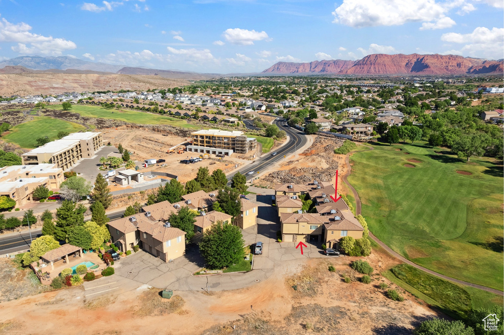 Aerial view of residential area featuring a mountainous background and a local golf course
