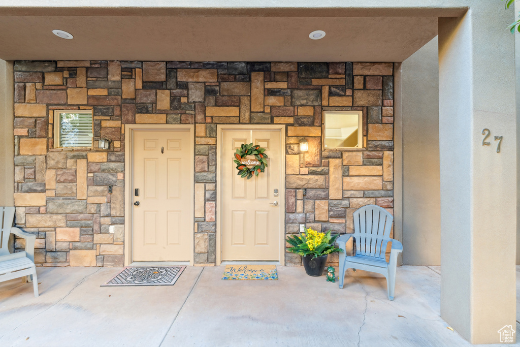 Entrance to property featuring stone siding