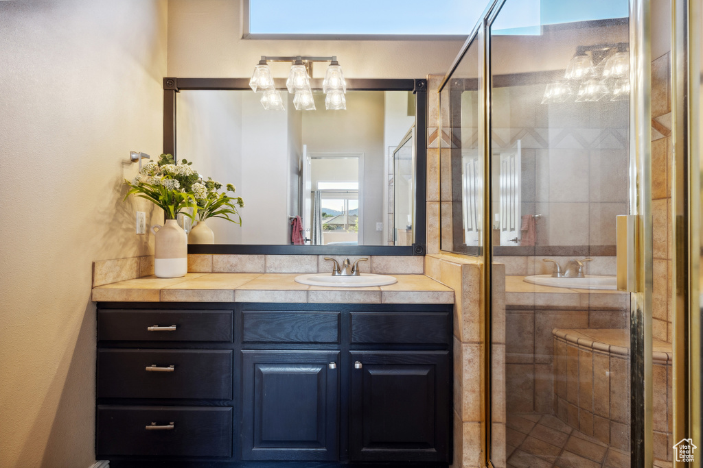 Full bath featuring vanity, a stall shower, and a chandelier