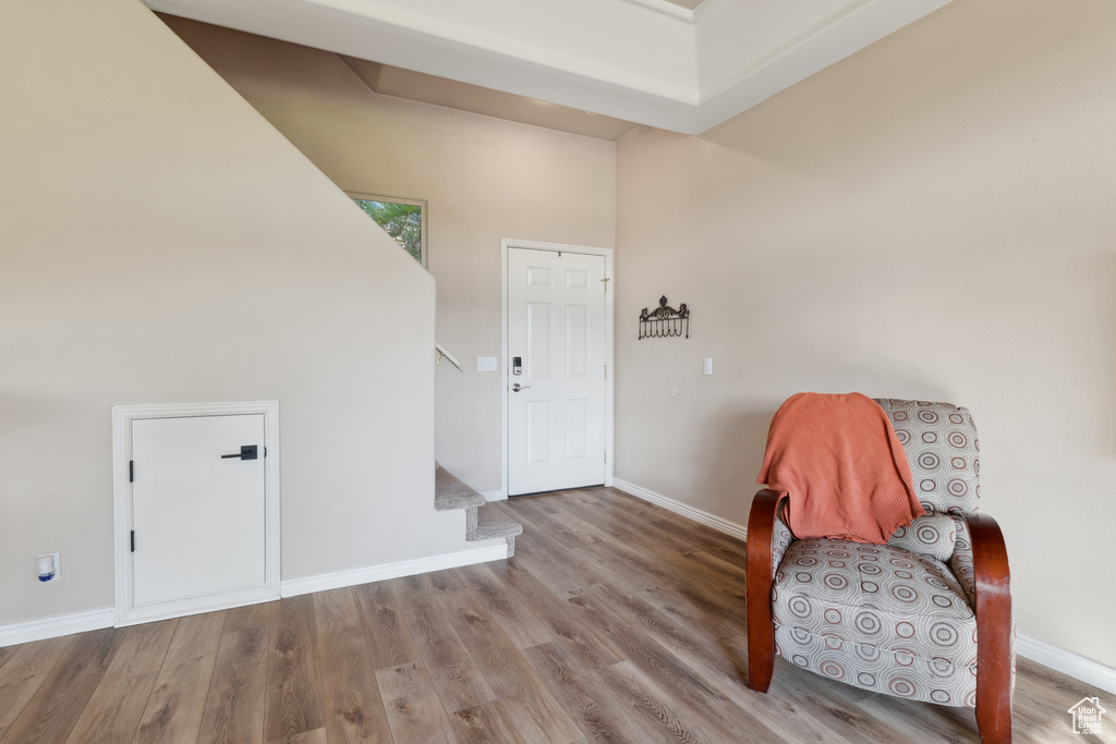 Living area with wood finished floors, stairway, and a high ceiling