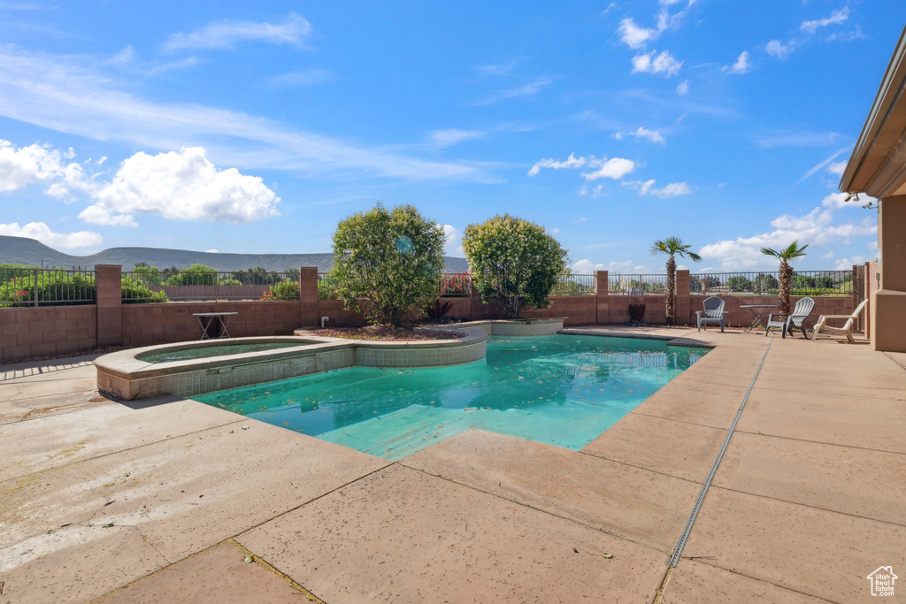 View of swimming pool with a patio, a fenced backyard, and a pool with connected hot tub