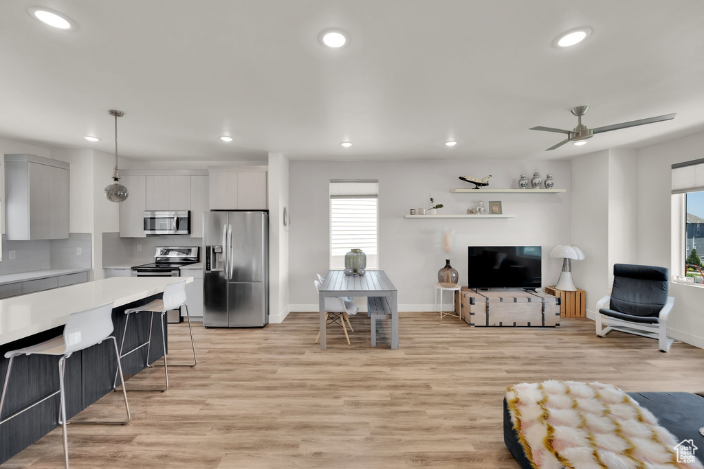Living room featuring recessed lighting, baseboards, light wood-type flooring, and ceiling fan