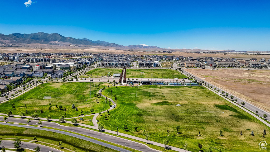 Aerial view of property and surrounding area featuring nearby suburban area and a mountainous background