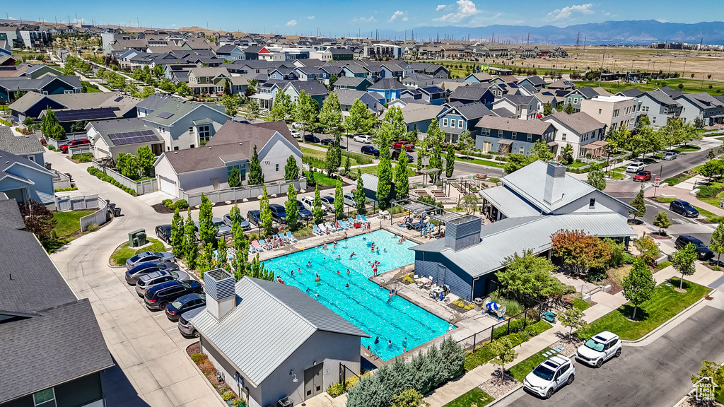 Aerial perspective of suburban area with a pool area and a mountainous background