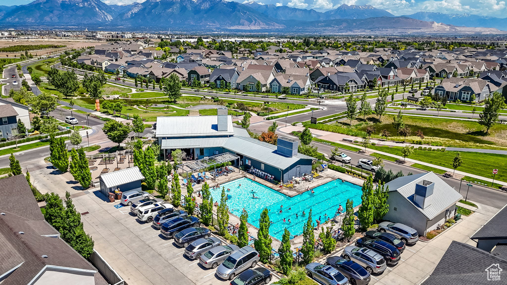 Aerial view of residential area featuring mountains and a pool area