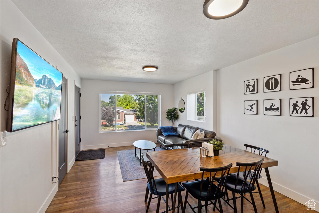 Dining area with wood finished floors and a textured ceiling