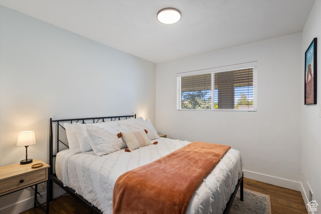 Bedroom with wood finished floors and baseboards