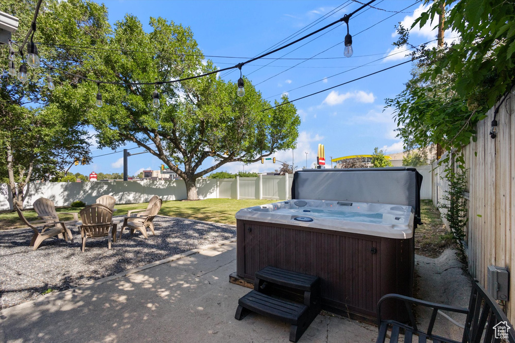 Fenced backyard featuring a hot tub and a patio