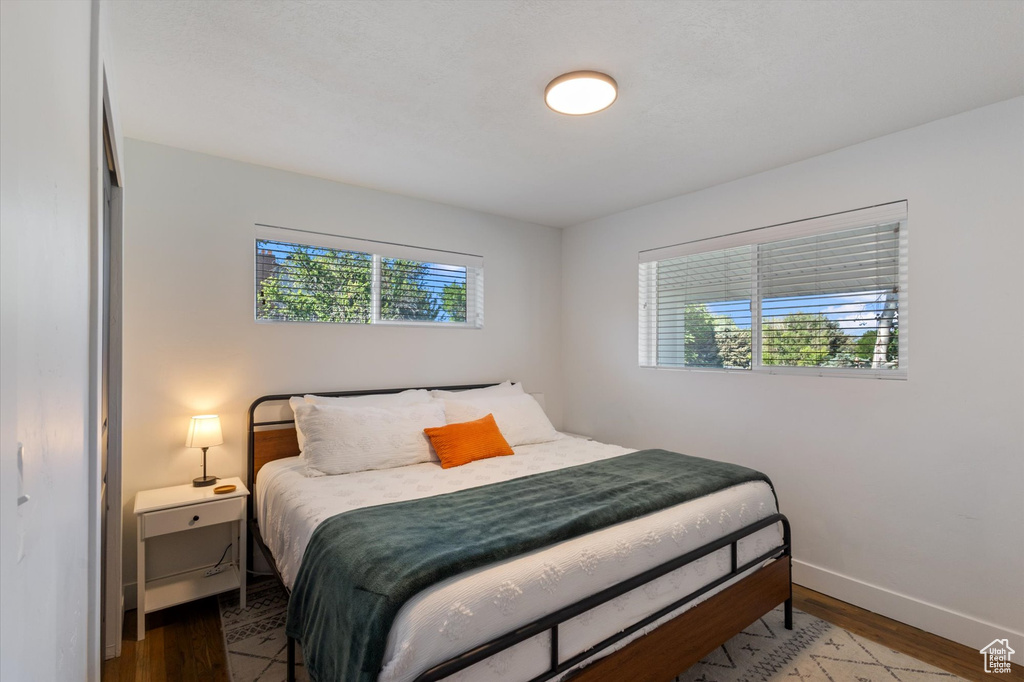 Bedroom with wood finished floors and baseboards
