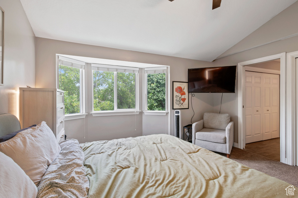 Bedroom with carpet floors, lofted ceiling, and ceiling fan