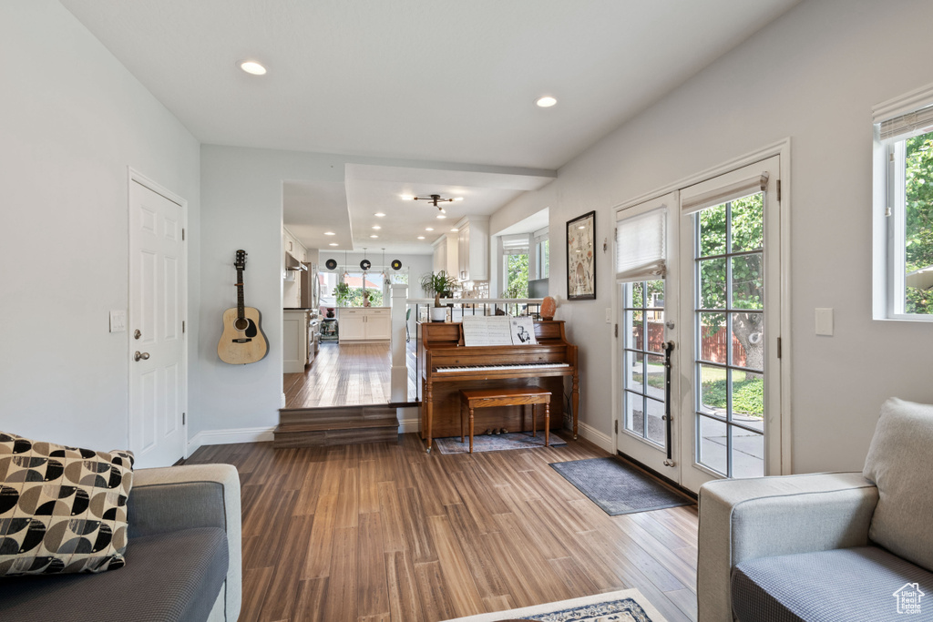 Living area with plenty of natural light, wood finished floors, recessed lighting, and baseboards