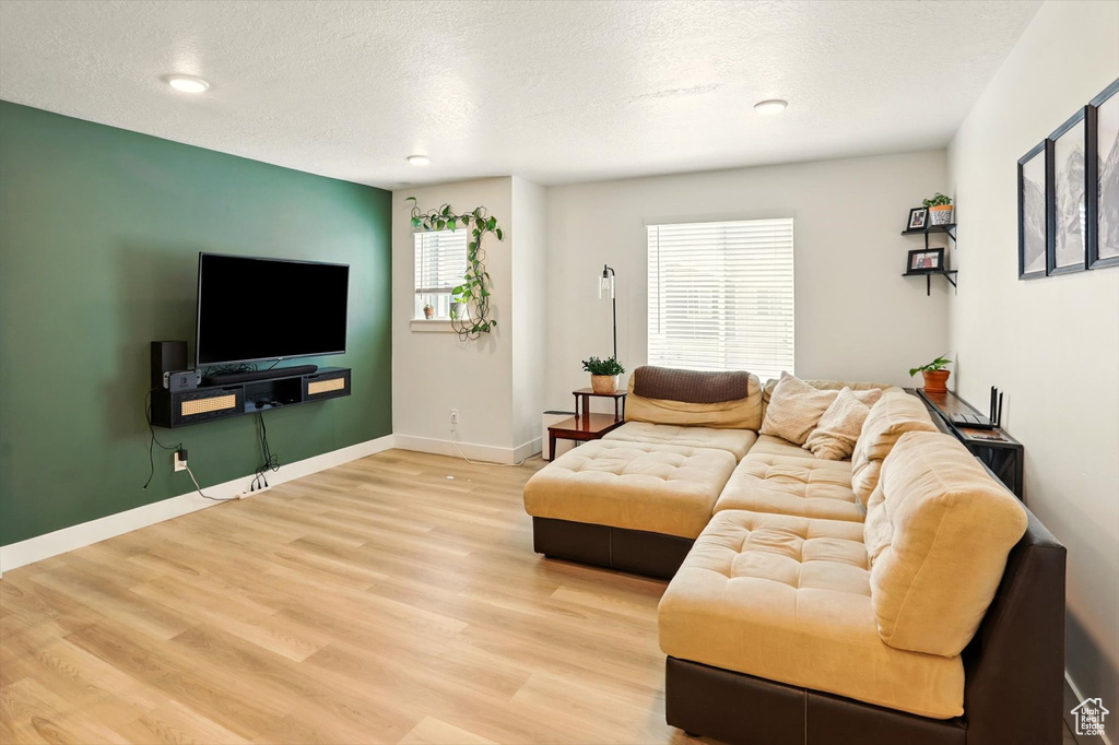 Living room featuring wood finished floors, a textured ceiling, and recessed lighting