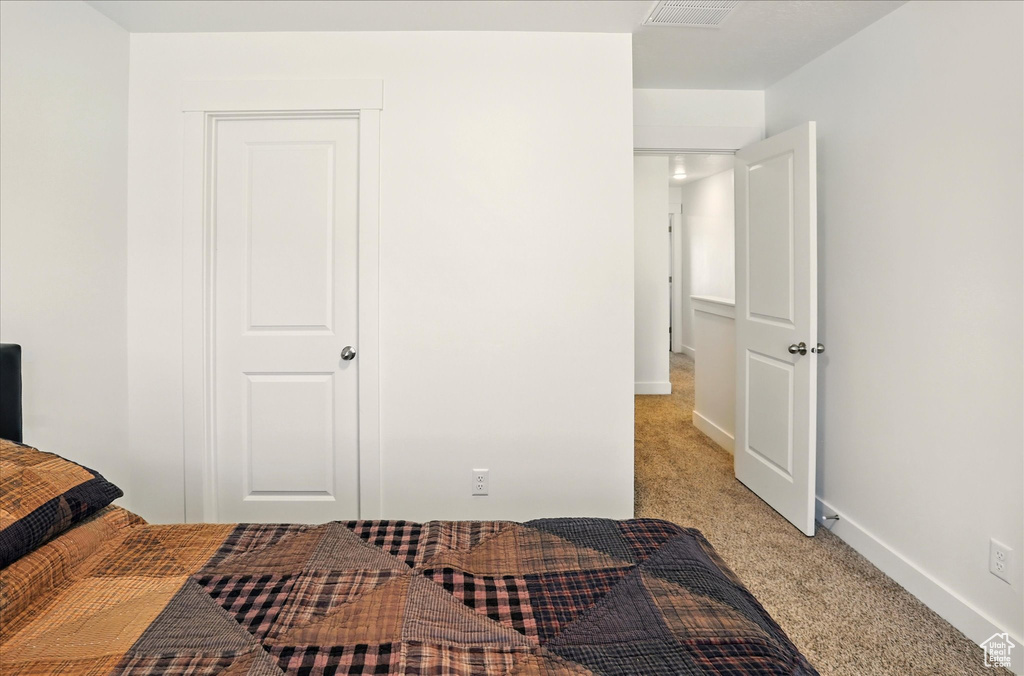 Bedroom with light colored carpet and baseboards