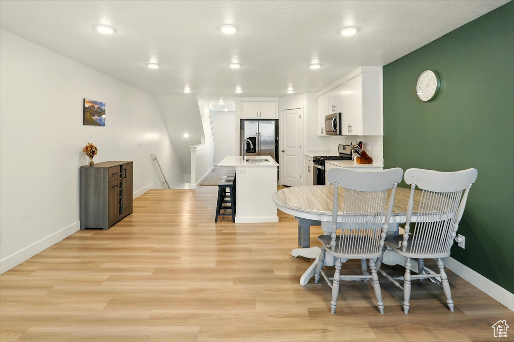 Dining space featuring light wood-type flooring and recessed lighting