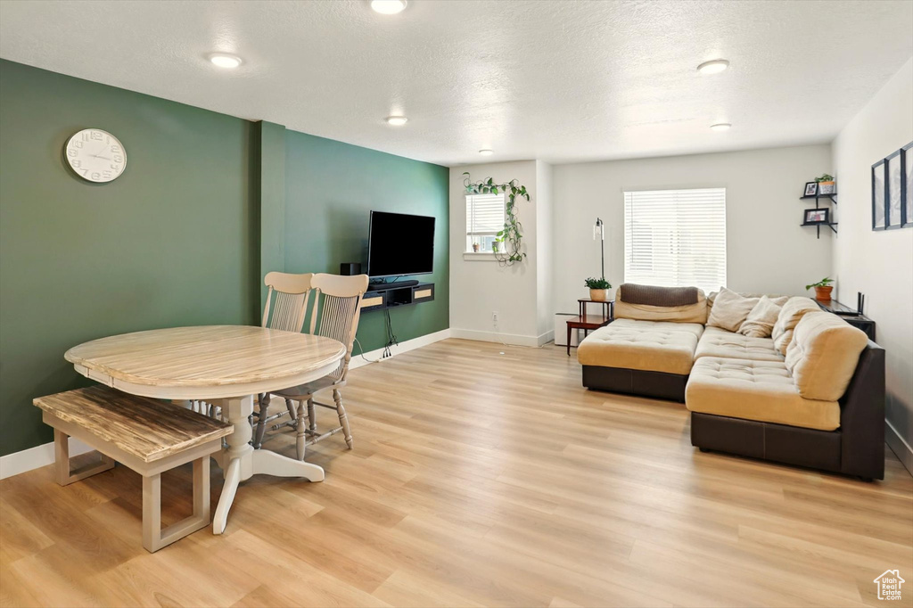Living area with light wood finished floors and recessed lighting