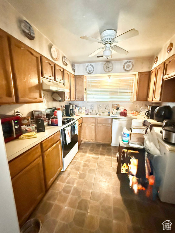 Kitchen with white range, dishwashing machine, under cabinet range hood, light countertops, and a ceiling fan