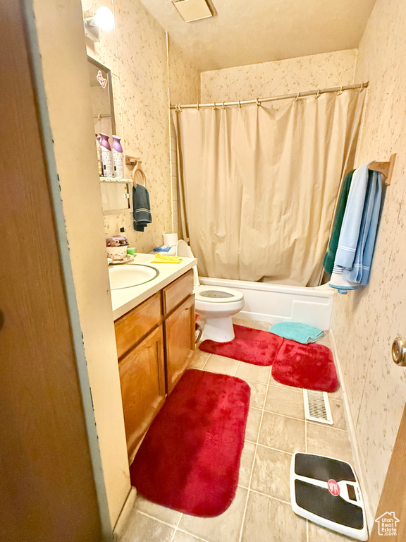 Bathroom featuring tile patterned floors, shower / tub combo, and vanity