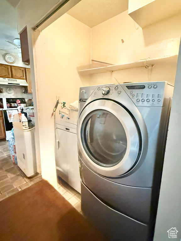 Laundry room featuring light tile patterned floors and washer and clothes dryer