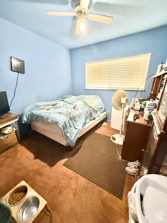Carpeted bedroom featuring a desk and ceiling fan