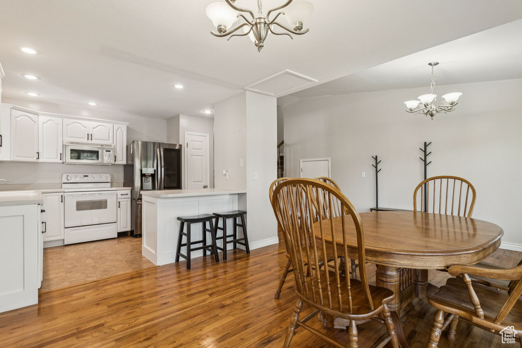 Dining area featuring a chandelier, light wood finished floors, and recessed lighting