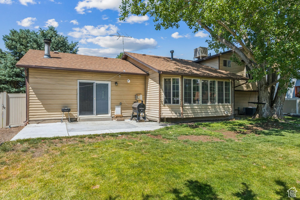 Rear view of property featuring a patio area and a shingled roof