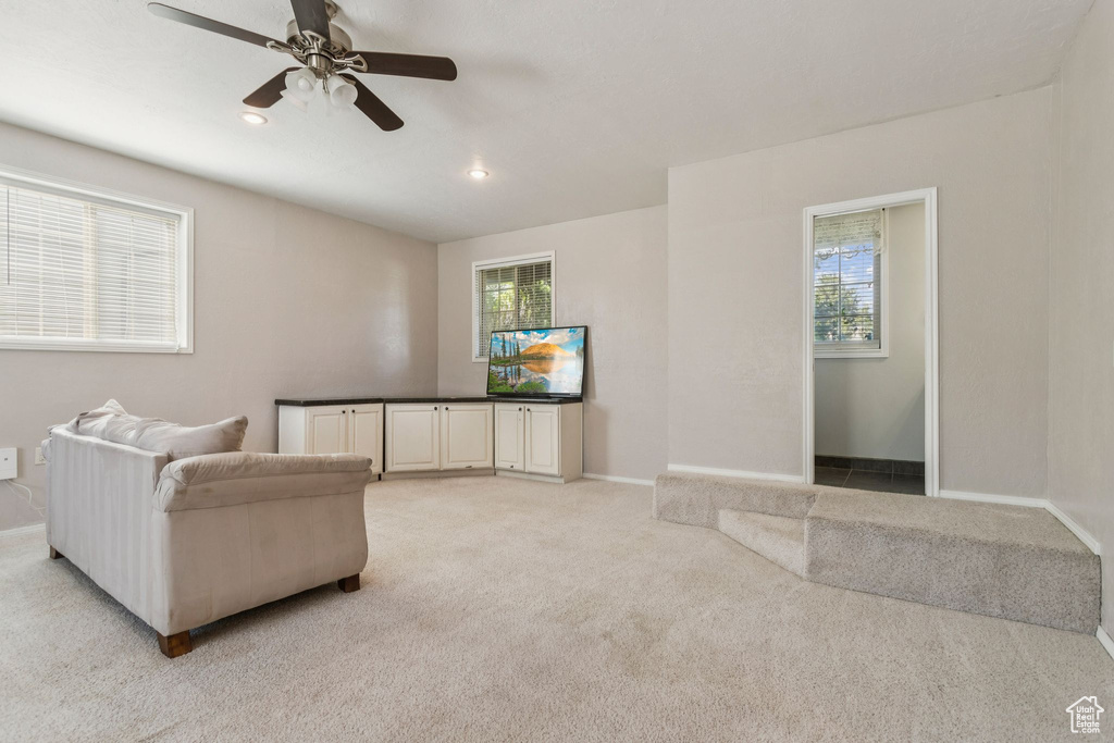 Living room featuring a ceiling fan, light colored carpet, and recessed lighting