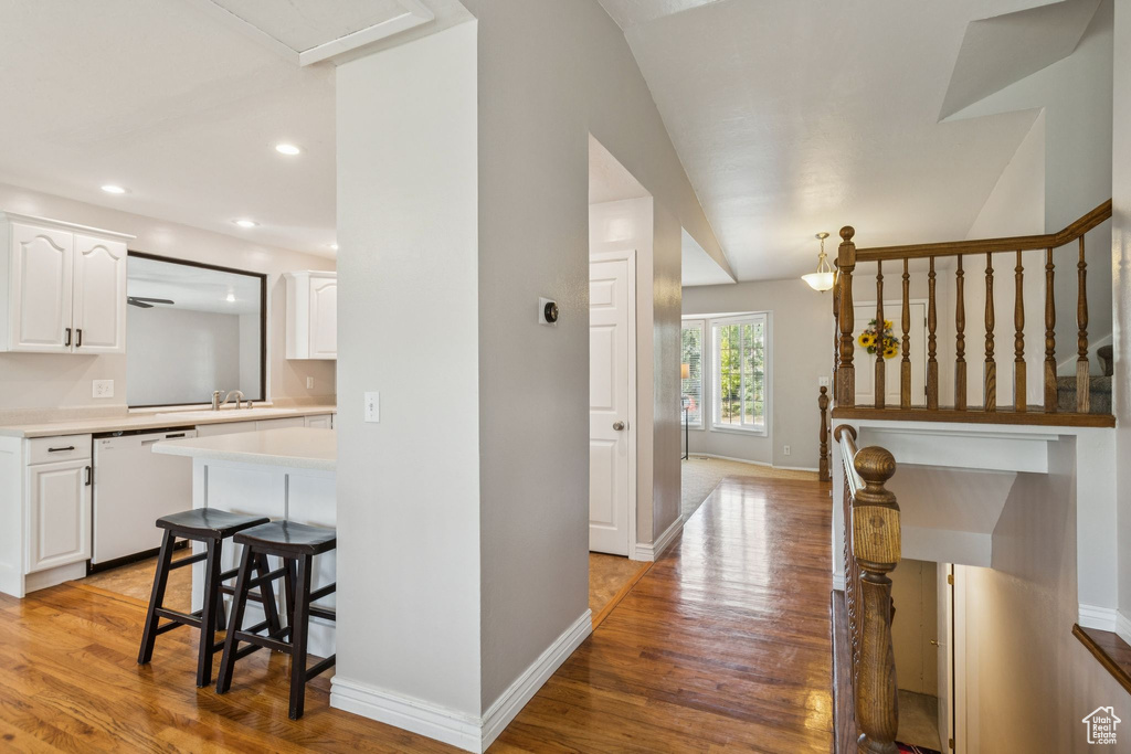 Hall with light wood-style floors, lofted ceiling, and recessed lighting
