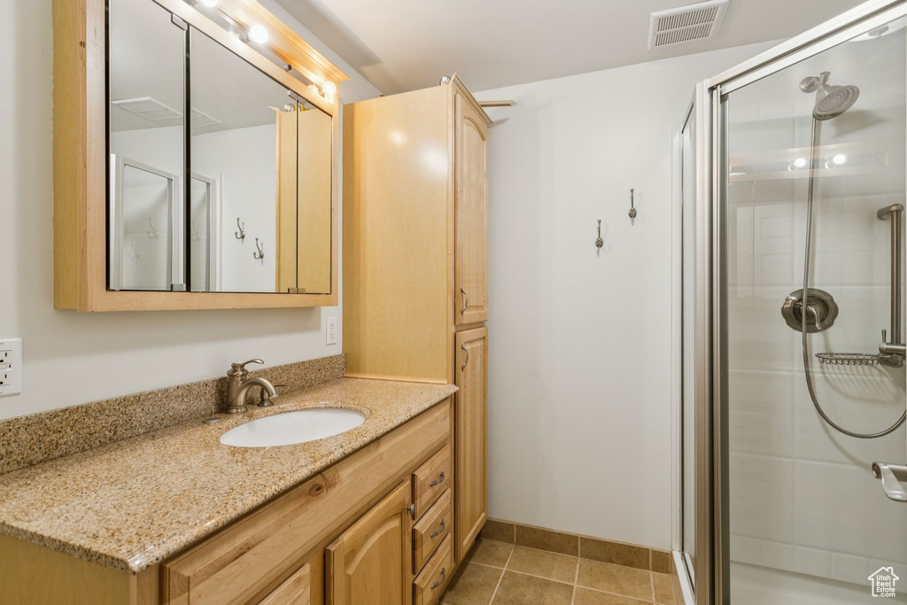 Bathroom with vanity, a stall shower, and tile patterned floors