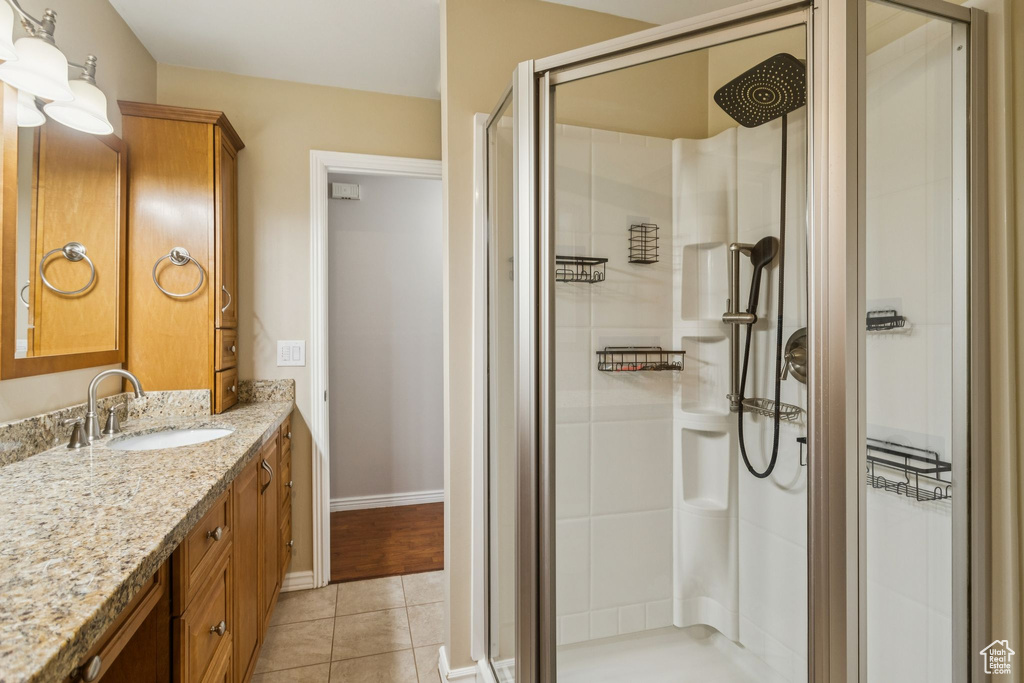 Bathroom with vanity, a shower stall, and tile patterned flooring