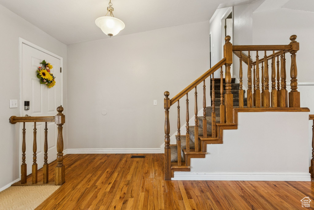 Foyer with wood finished floors and stairway