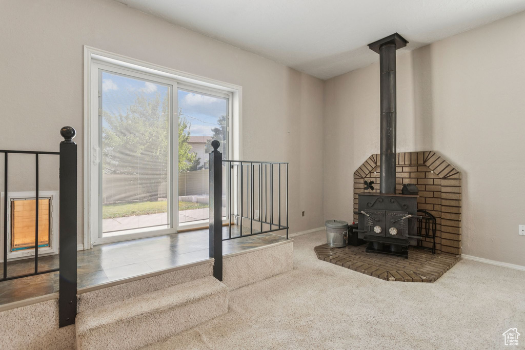 Living area featuring a wood stove and carpet flooring