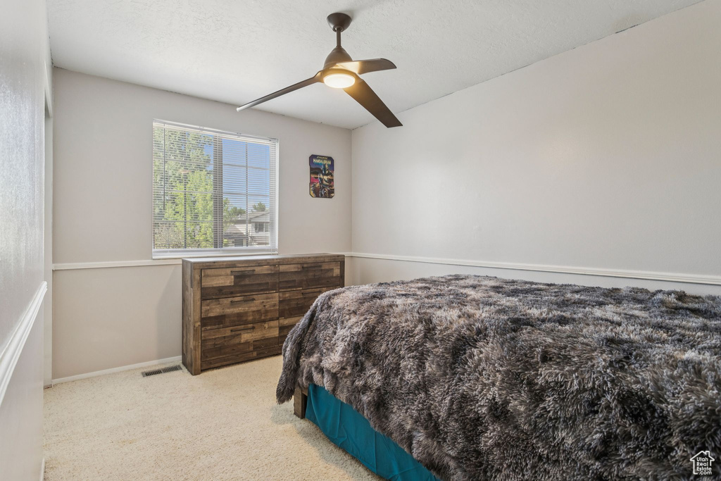 Carpeted bedroom featuring ceiling fan and baseboards