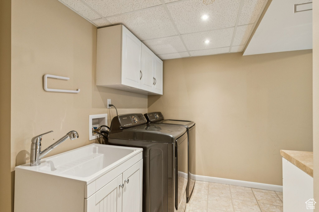 Laundry area with cabinet space, washing machine and clothes dryer, recessed lighting, and light tile patterned floors
