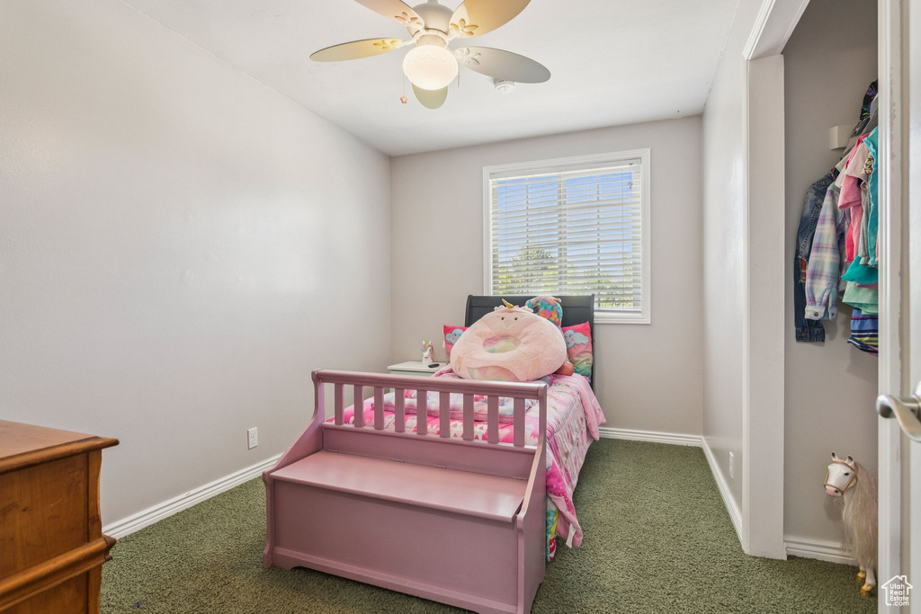 Carpeted bedroom with baseboards and a ceiling fan