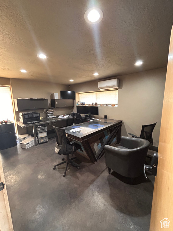 Office with a wall mounted air conditioner, concrete flooring, recessed lighting, and a textured ceiling